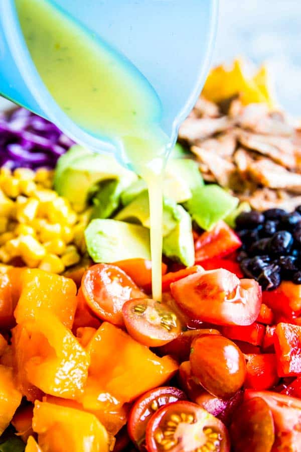 pouring dressing on chicken taco salad