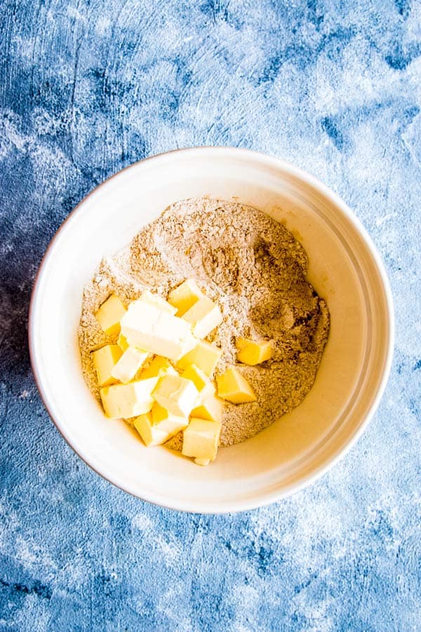 dry ingredients with butter in a bowl for a peach cobbler biscuit topping