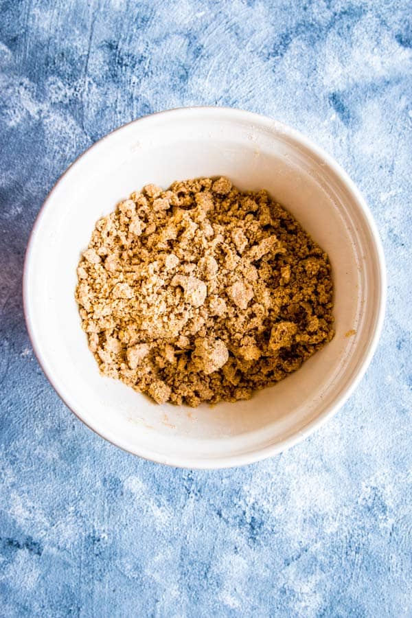 flour and butter rubbed together in a bowl to make biscuit topping for peach cobbler