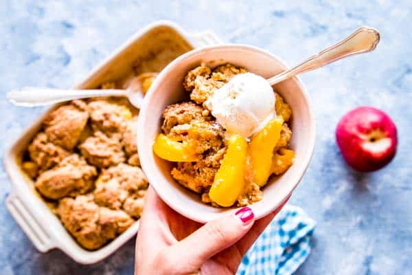 holding a bowl of peach cobbler with ice cream