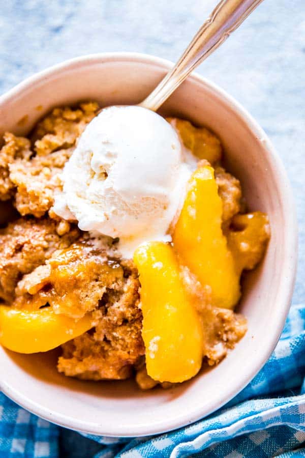 closer photo of a bowl with fresh peach cobbler and ice cream