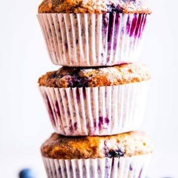 three greek yogurt blueberry muffins stacked on top of each other