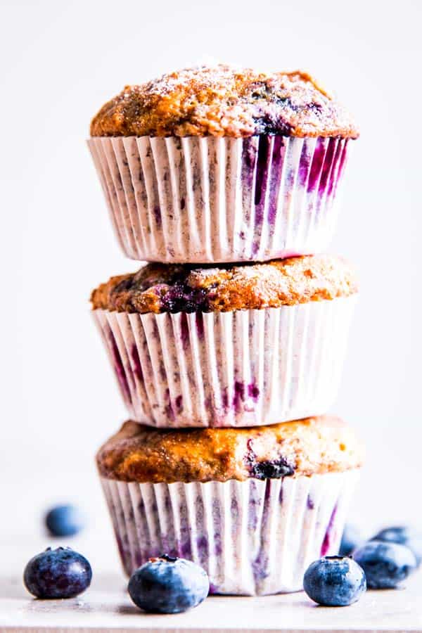 three greek yogurt blueberry muffins stacked on top of each other