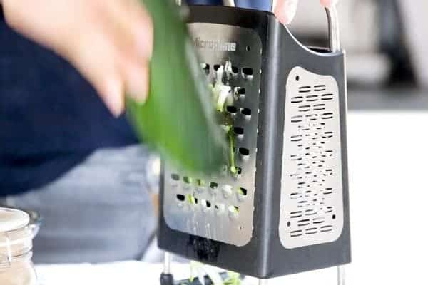 shredding zucchini on a box grater