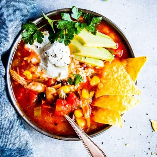 chicken tortilla soup in a black bowl