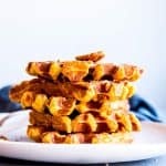 stack pf pumpkin pecan waffles on a white plate