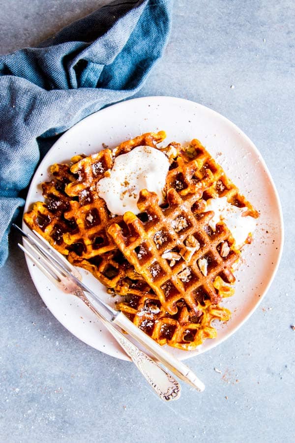 pumpkin pecan waffles on a white plate with a dark napkin