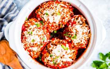 four stuffed peppers in a white crockpot