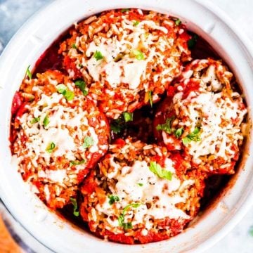 four stuffed peppers in a white crockpot