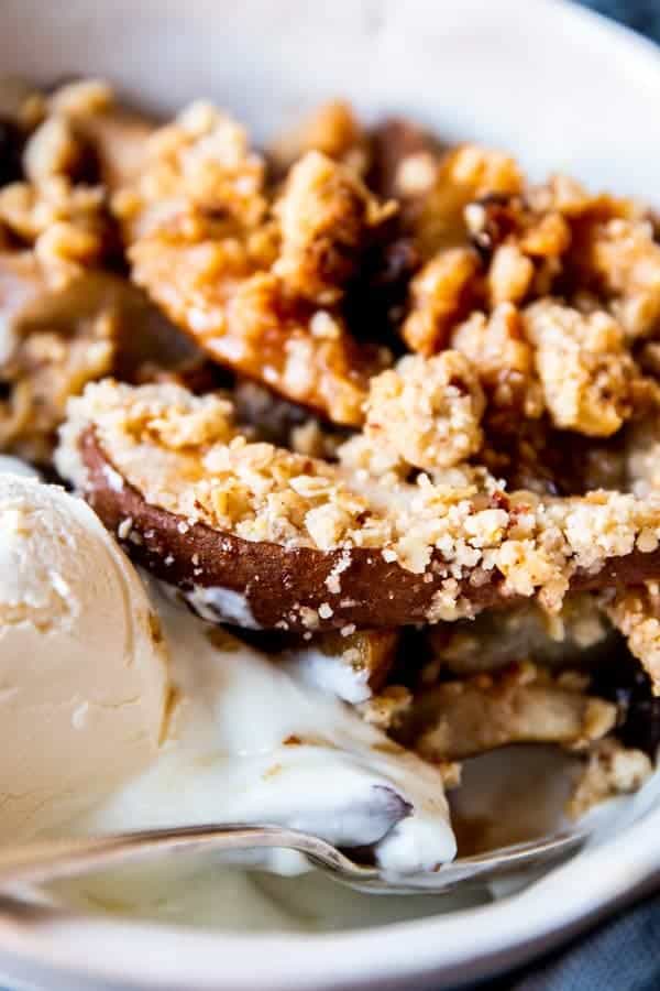 close up of pear crisp with ice cream in a bowl