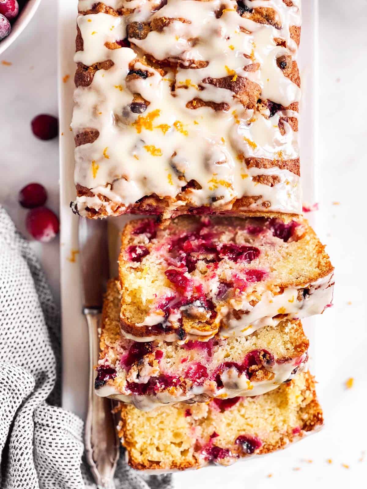 overhead view of sliced cranberry orange bread on a white platter