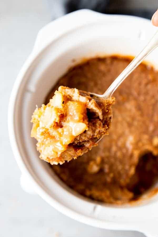 scooping apple cobbler from a crockpot