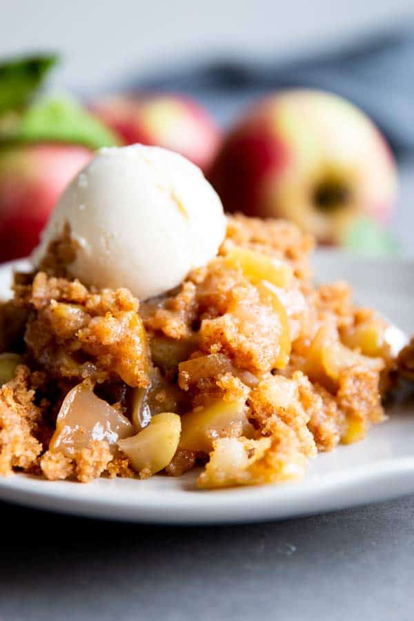 Crockpot Apple Cobbler is an easy and delicious dessert for cozy fall and winter nights. Serve it with a scoop of vanilla ice cream for an extra treat! | #recipe #fallrecipes #crockpot crockpot apple cobbler on a plate with ice cream