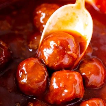 spooning cranberry bbq meatballs from a crockpot