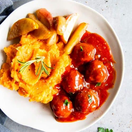 crockpot cranberry bbq meatballs on a plate with sides