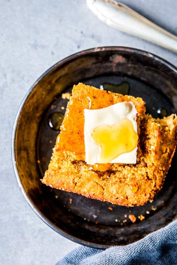 slice of honey butter cornbread on a black plate