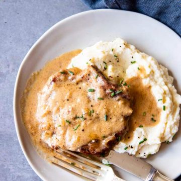 instant pot sour cream pork chops on a plate with mashed potatoes