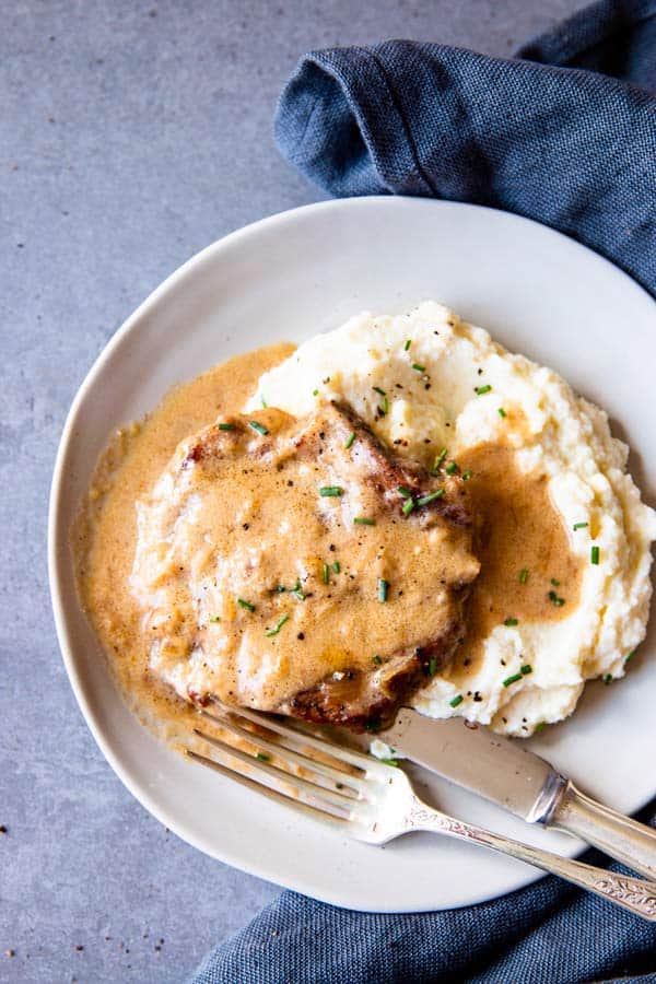 instant pot sour cream pork chops on a plate with mashed potatoes