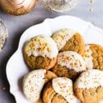 a plate with chewy gingersnap cookies next to Christmas ornaments