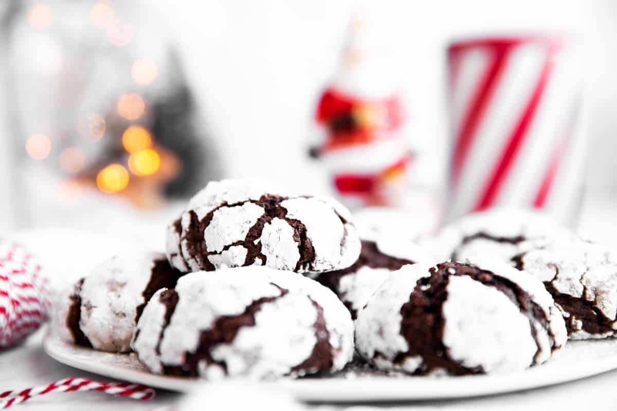plate with chocolate crinkle cookies in front of Christmas ornaments
