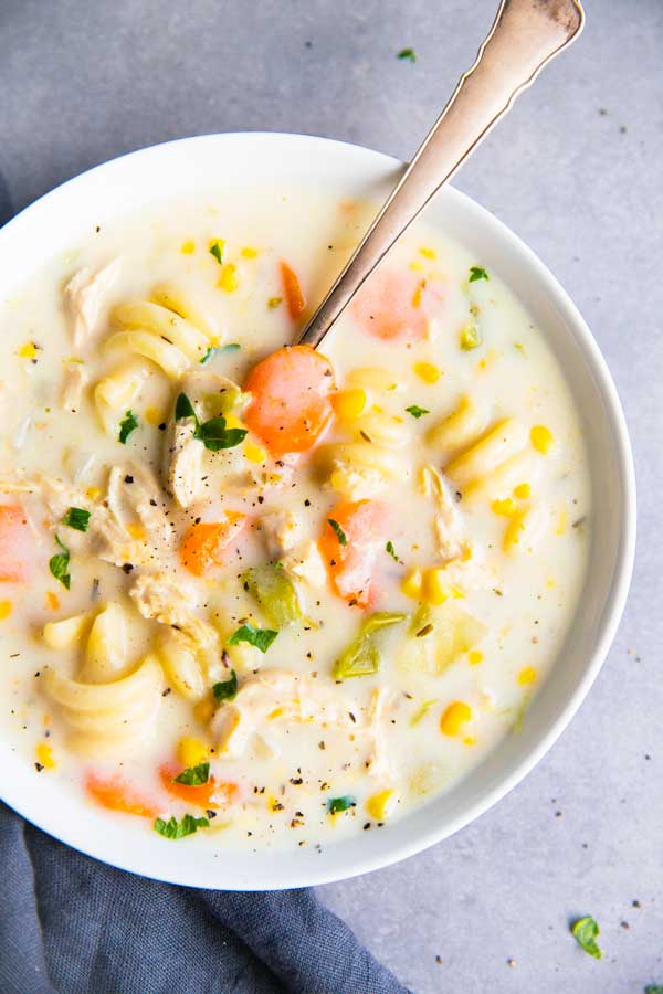 close up photo of a bowl with creamy crockpot chicken noodle soup