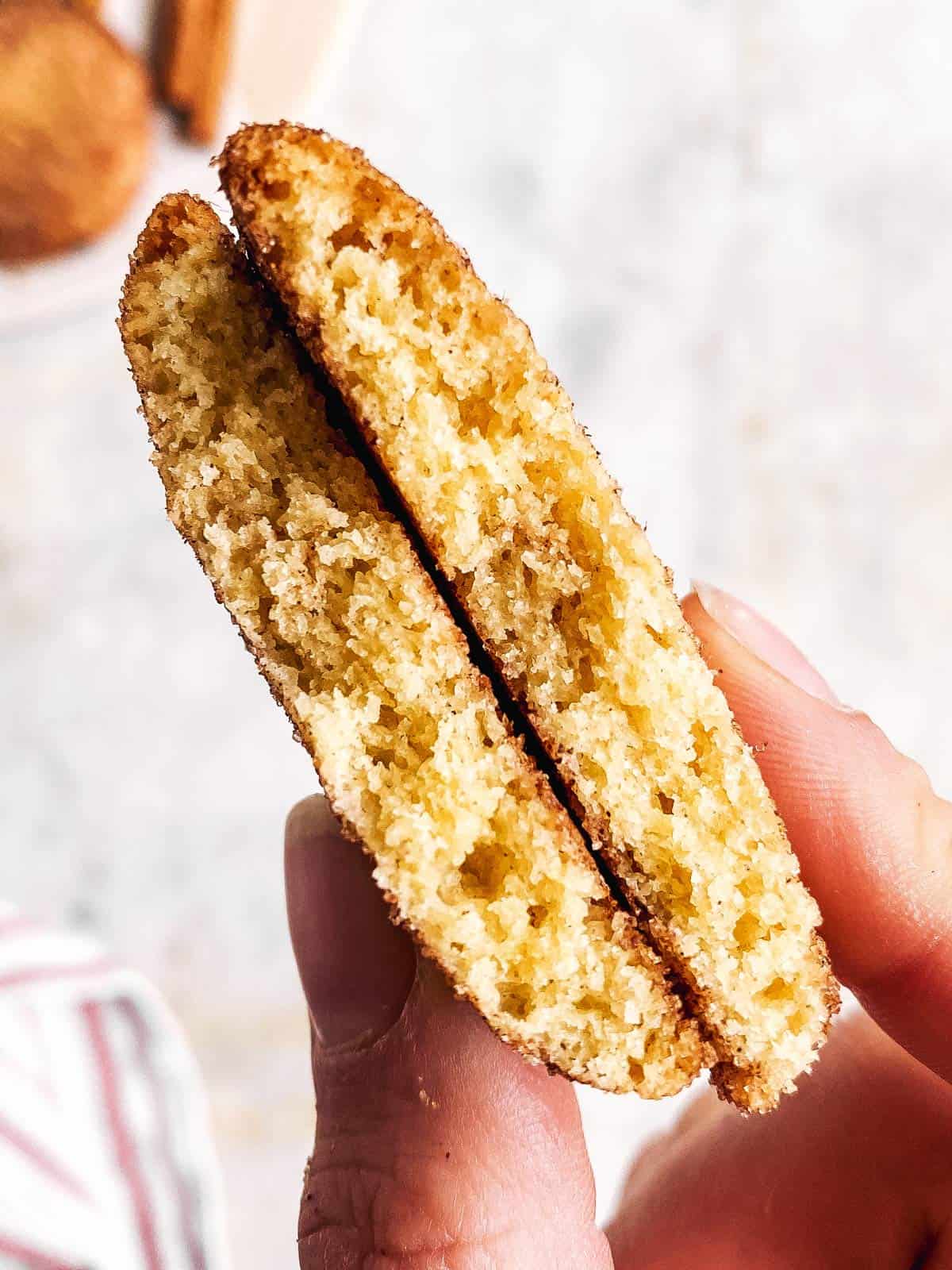 female hand holding halved snickerdoodle cookie