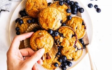 top down view on plate with oatmeal muffins, female hand grabbing one