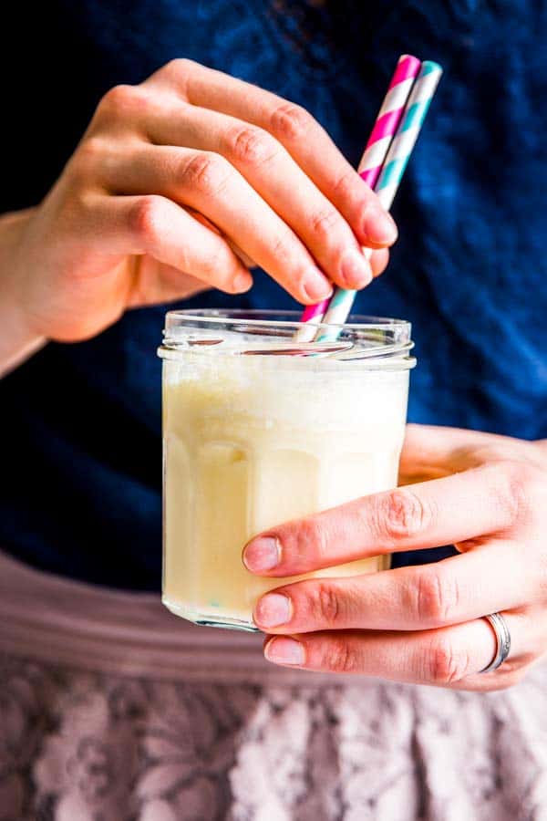 woman holding a coconut pineapple smoothie