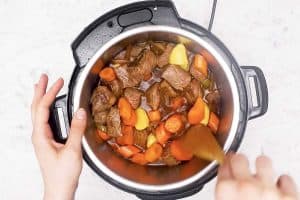 female hand stirring irish stew in instant pot