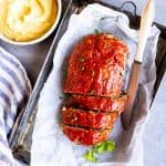 sliced meatloaf on the table with mashed potatoes and carrots