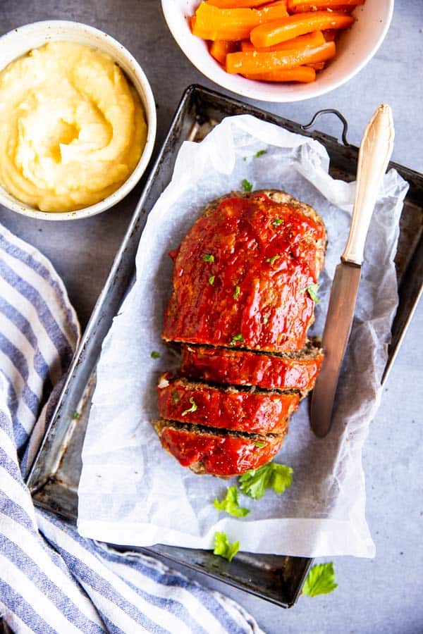 sliced meatloaf on the table with mashed potatoes and carrots