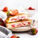 stack of stuffed French toast on a plate with fresh strawberries