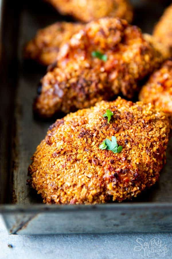 close up photo of cornmeal oven fried chicken on a baking pan