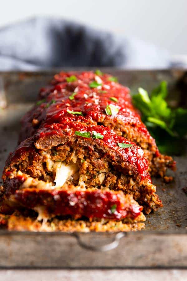 sliced mozzarella stuffed meatloaf on a sheet pan