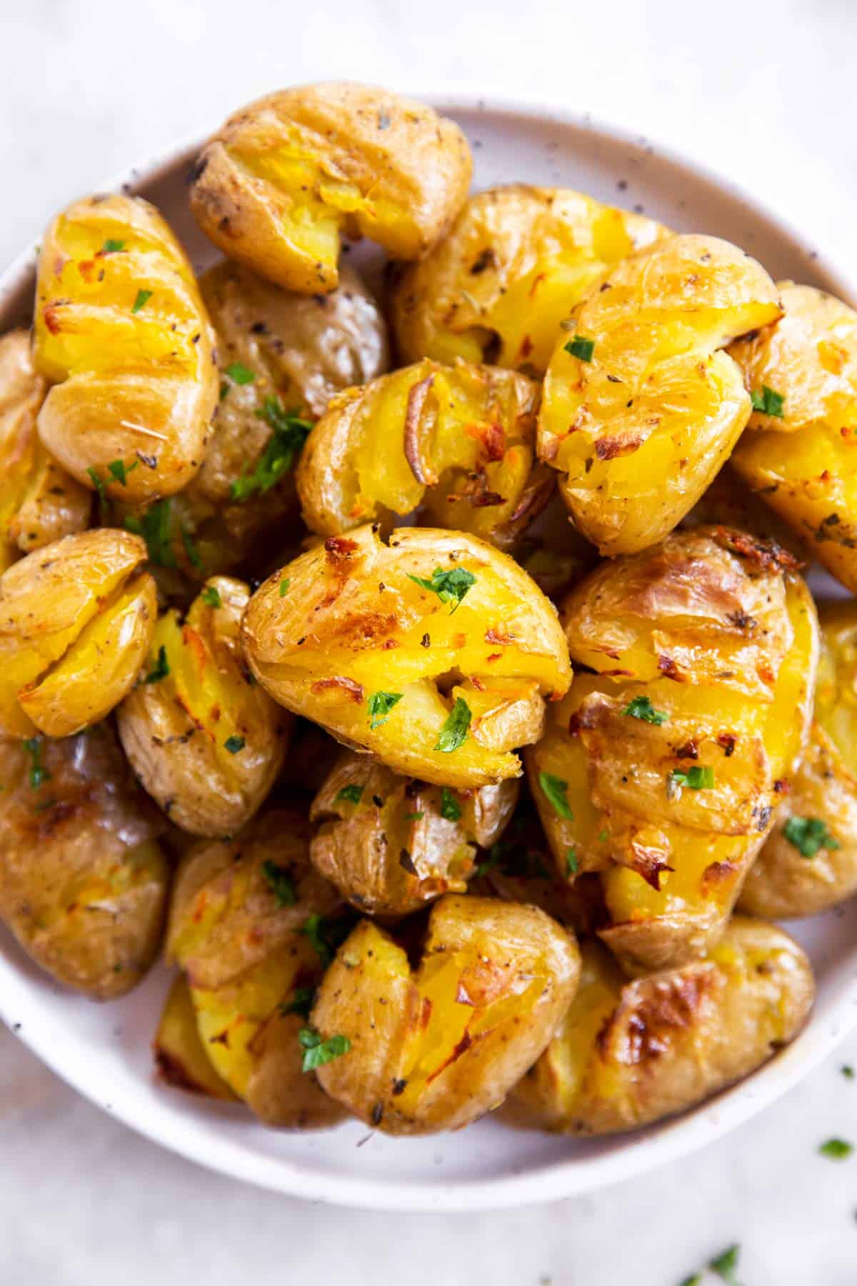 smashed potatoes on white serving platter