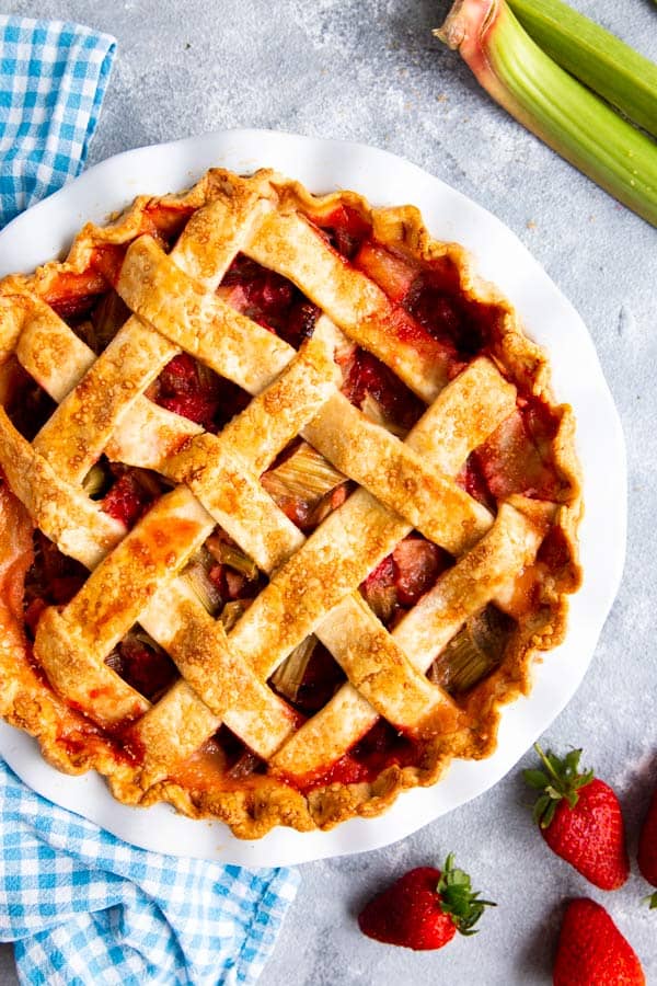 strawberry rhubarb pie with lattice crust in a white pie plate