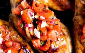 grilled chicken with bruschetta topping on a grill pan