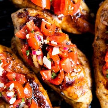 grilled chicken with bruschetta topping on a grill pan