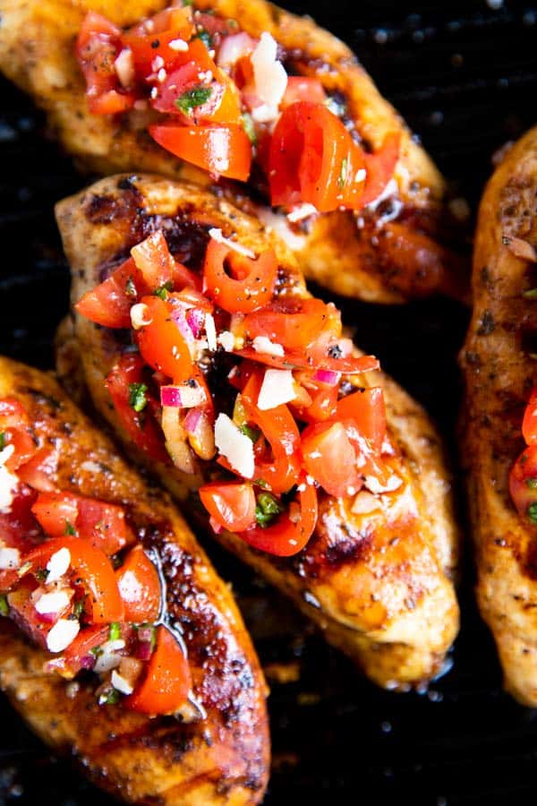 grilled chicken with bruschetta topping on a grill pan