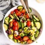 overhead view of white bowl with tomato cucumber avocado salad
