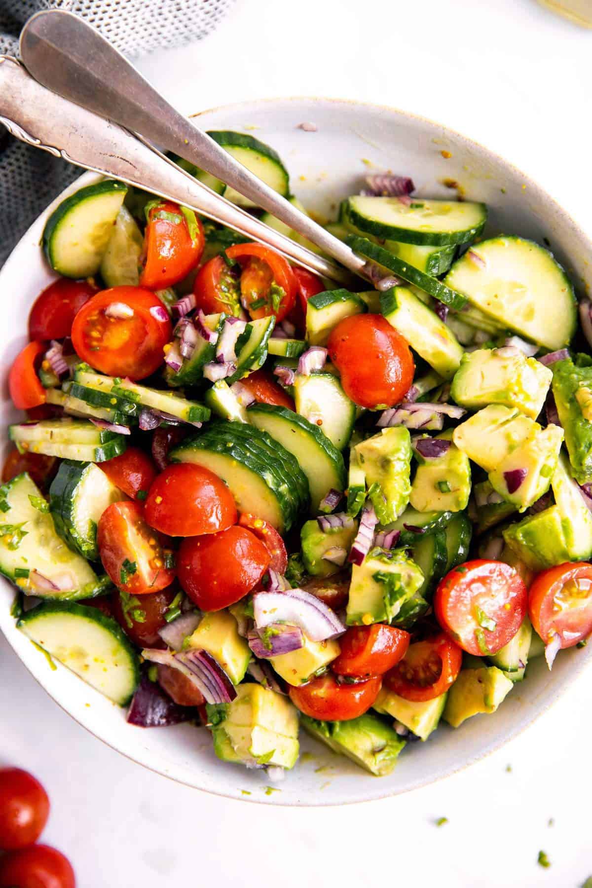 white bowl with tomato cucumber avocado salad