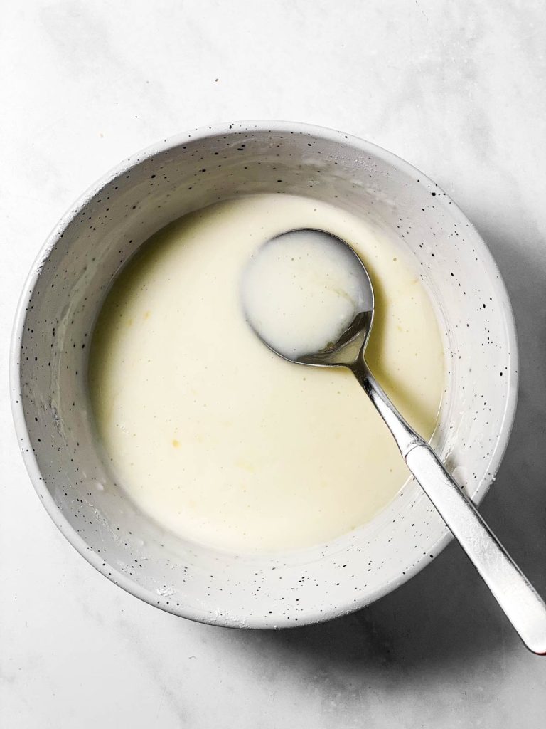 thick lemon glaze in white bowl with spoon