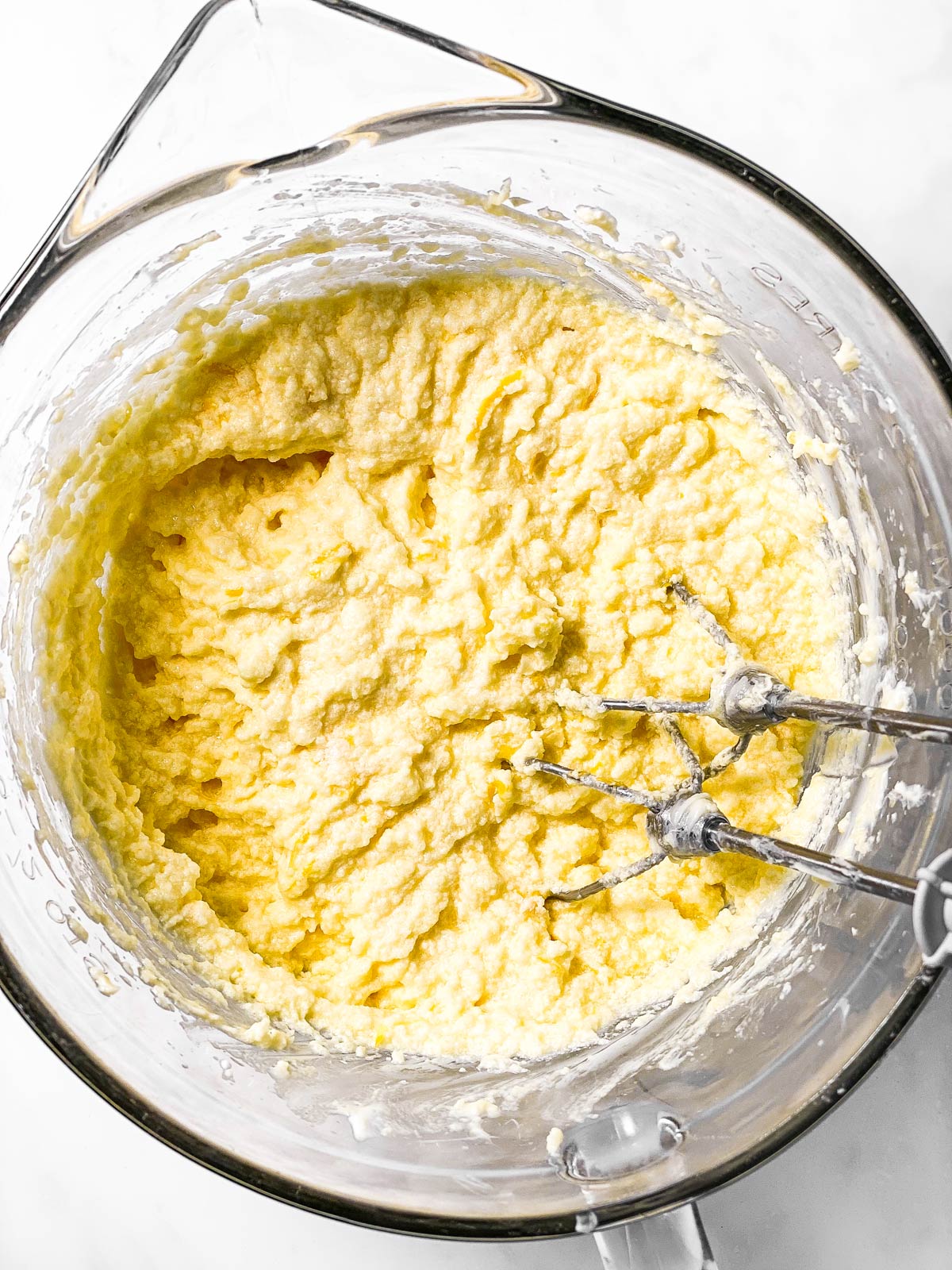 beaten eggs and sugar in glass bowl with mixer beaters