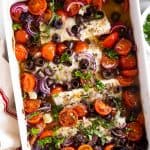 overhead view of white casserole dish filled with mediterranean baked cod