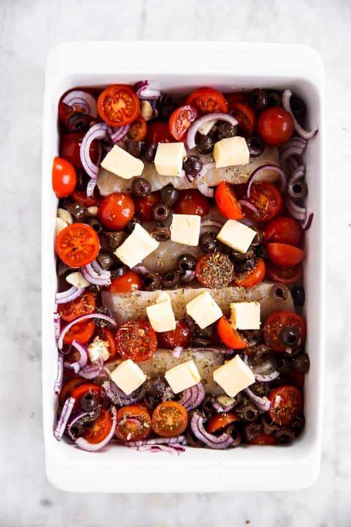 mediterranean baked cod assembled with butter, ready to be baked