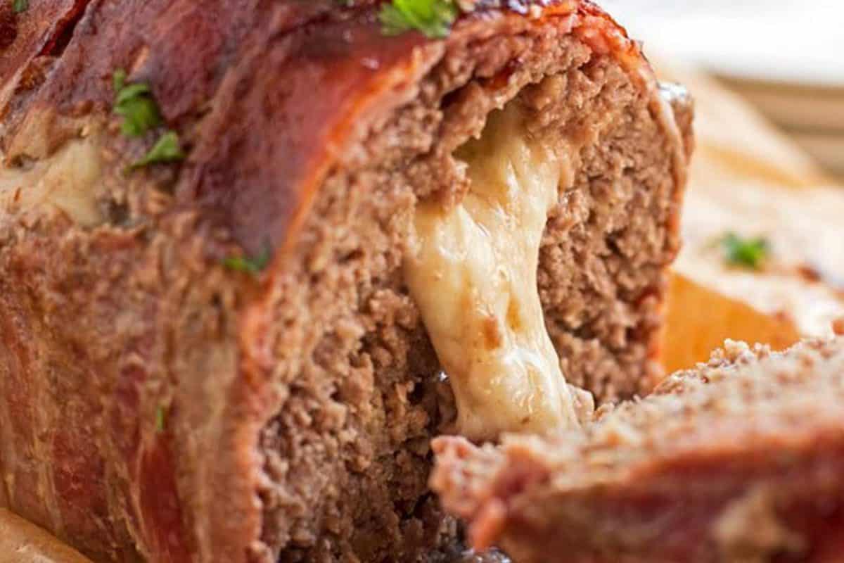 close up photo of melted mozzarella cheese oozing out of a sliced meatloaf