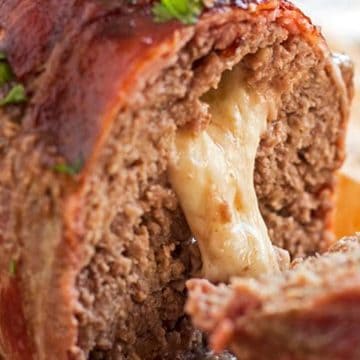 close up photo of melted mozzarella cheese oozing out of a sliced meatloaf