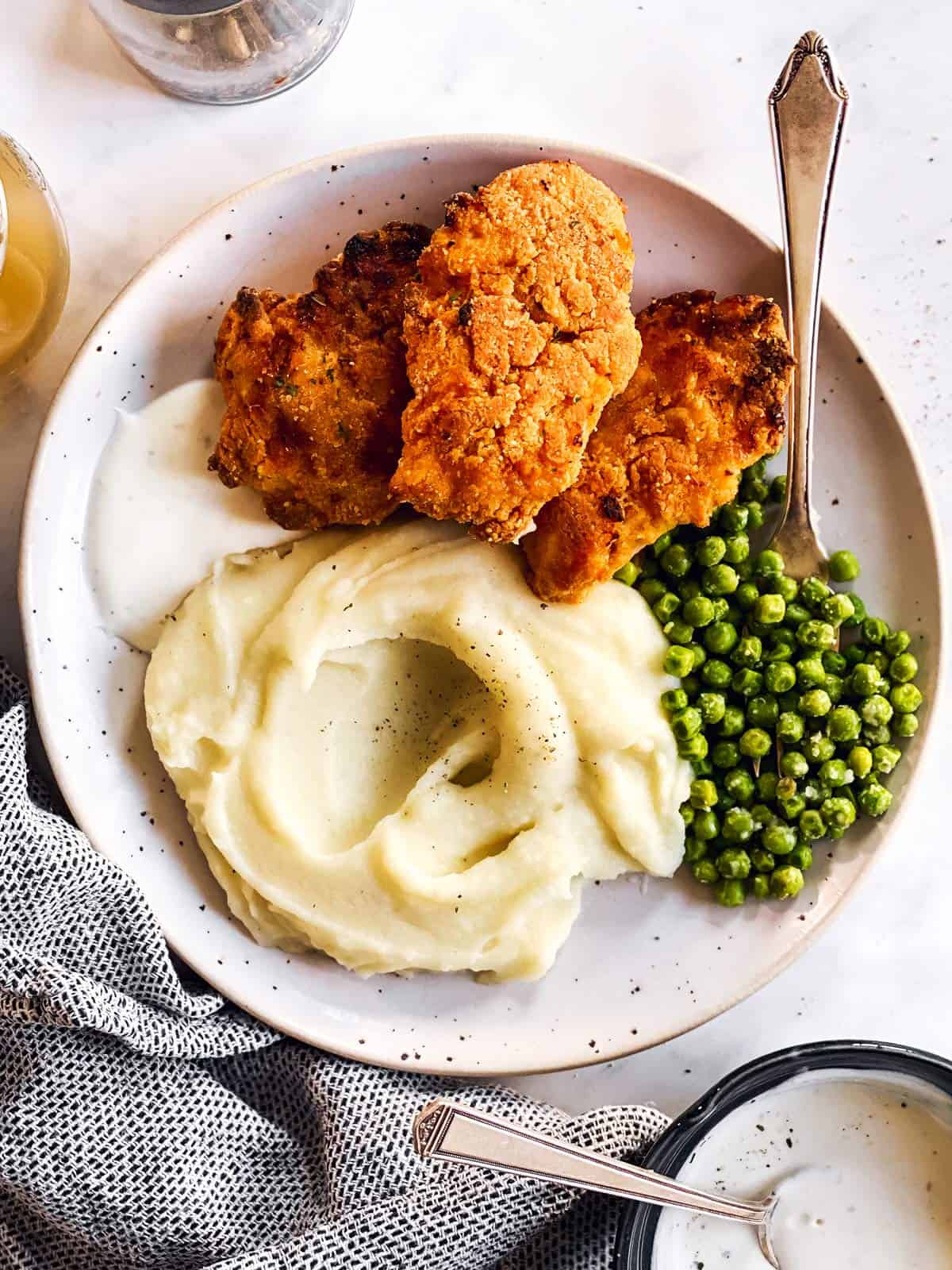 plate with mashed potatoes, peas and fried chicken