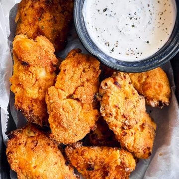 close up photo of buttermilk oven fried chicken on a lined pan