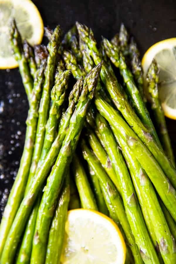 pile of roasted asparagus with lemon slices